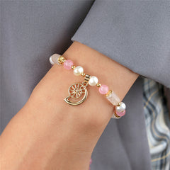 Pearl Bracelet With Light Pink Pearls And Golden Beads In Different Hawaiian Charms