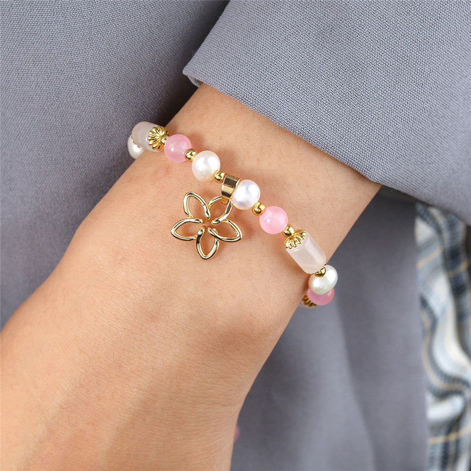 Pearl Bracelet With Light Pink Pearls And Golden Beads In Different Hawaiian Charms