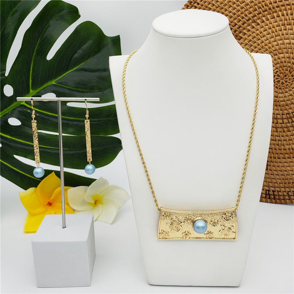 Set Of Hawaiian Beach Sand Of Turtles Necklace Centered With A Sky Blue Pearl And Carved Thin Bar Drop Earrings With A Sky Blue Pearl