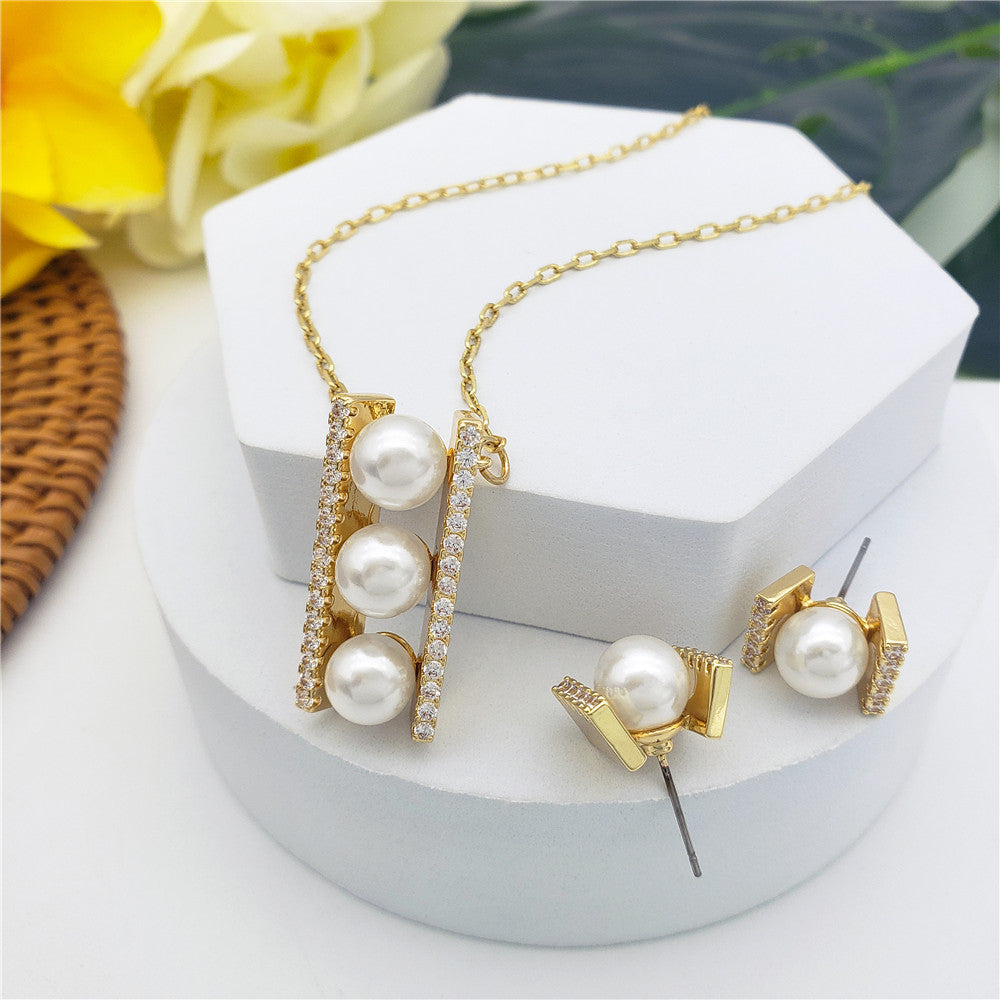 Set Of A Pearl With Wings Of White Zircons Earrings And Necklace With Pearls In Between Bars Of White Zircons In 2 Colors