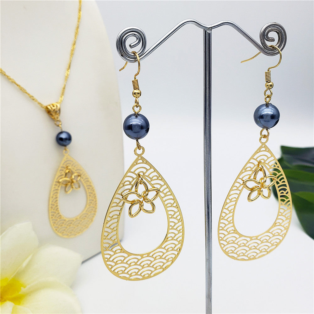 Set Of Carved Waves Double Teardrop Earrings And Necklace Sustained With A Petrol Pearl And Different Hawaiian Charms