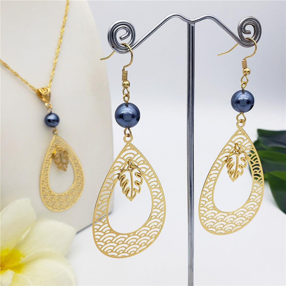 Set Of Carved Waves Double Teardrop Earrings And Necklace Sustained With A Petrol Pearl And Different Hawaiian Charms