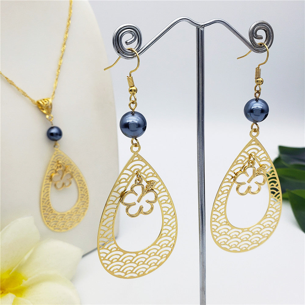 Set Of Carved Waves Double Teardrop Earrings And Necklace Sustained With A Petrol Pearl And Different Hawaiian Charms