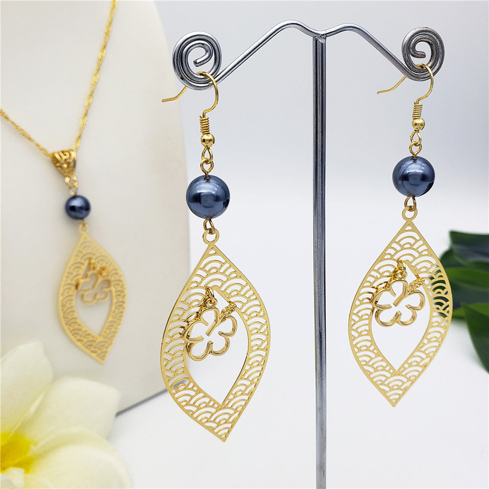 Set Of Carved Waves And Leaf Charm Earrings And Necklace Sustained With A Petrol Pearl And Different Hawaiian Charms